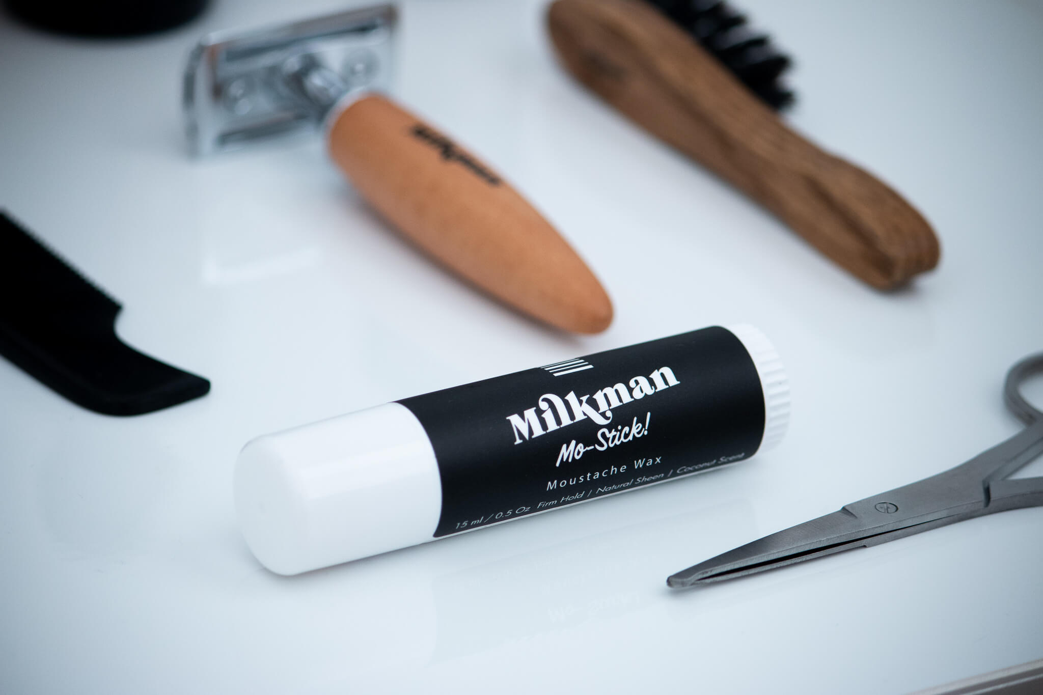 moustache wax close up with some tools from the moustache rescue kit on a white background